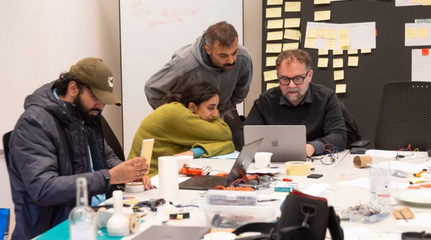 a photograph of people working at a desk