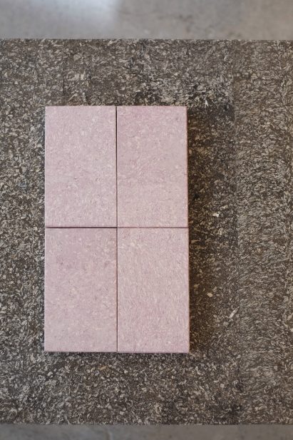 Photo of pale pink samples of Cupsan on a brown tableotp of the same biomaterial