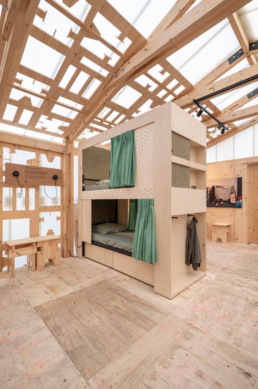 Photo of the De Wachtkamer privacy cabins showing storage solutions at the end and underneath and short green privacy curtains around the beds