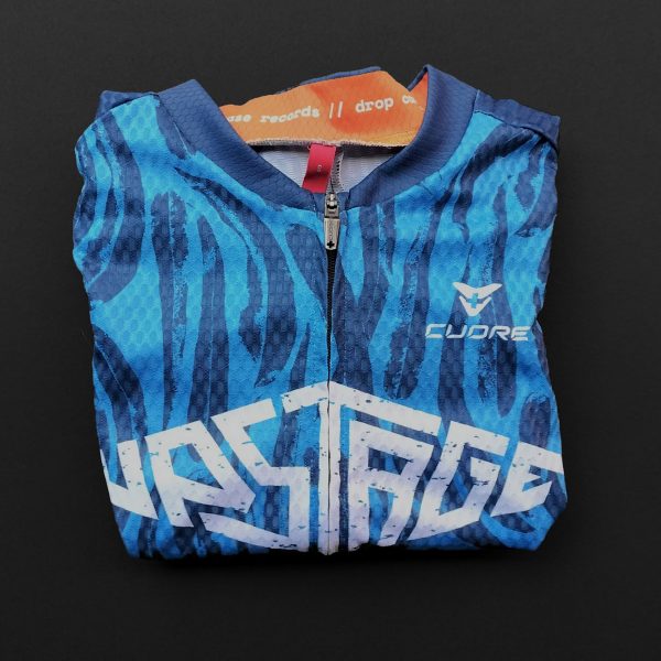 a photograph of a folded cycling jersey, in tones of blue and orange