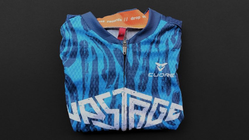 a photograph of a folded cycling jersey, in tones of blue and orange