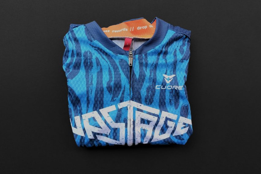 a photograph of a folded cycling jersey, in tones of blue and orange