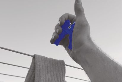 an image of a person's hand holding a blue clothes peg
