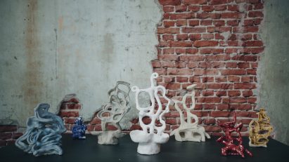 Photo of several ceramic sculptures with strange, squiggly forms arranged on a table