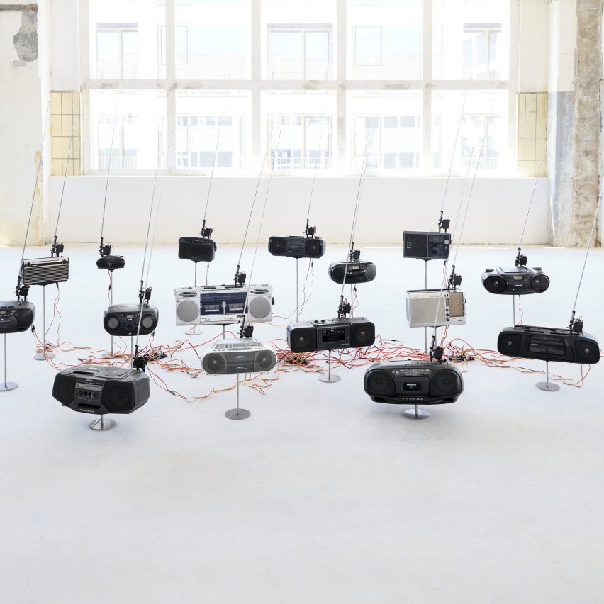Photo of the How to Catch the Fire Dragon installation by Kai-Hsiang Wen showing a dozen or so radios with their antennas up and curving to the right
