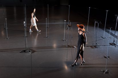 people walking around poles