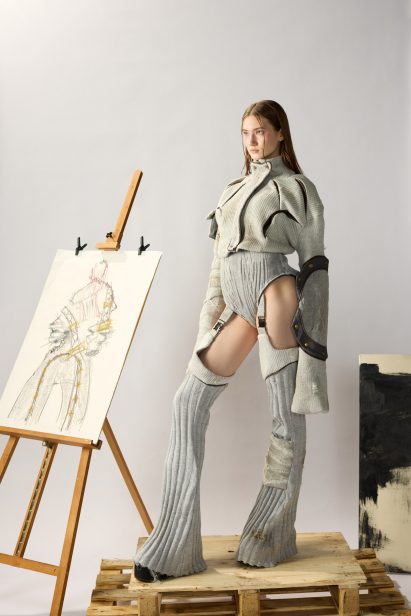 a photograph of a person standing next to a canvas