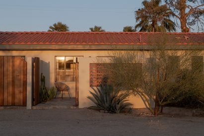 A patio with open gates onto the desert at sunset