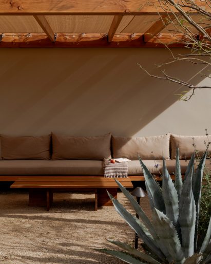 A shaded lounge area with a cushioned sofa