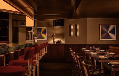 Bar and restaurant with wood panelling, glossy black tables and low lighting