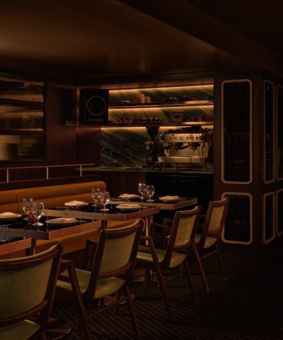 Glossy black tables positioned against tubular tan leather banquettes