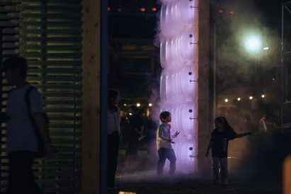 Kids playing by illuminated artwork