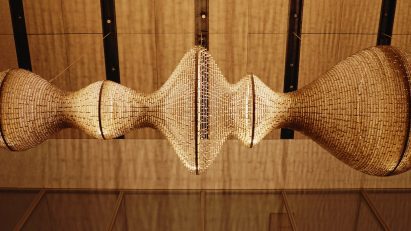 Undulating light sculpture suspended in a glass-fronted lobby space