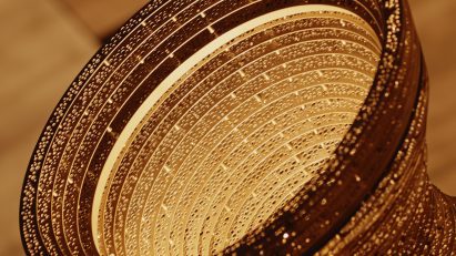 Detailed view of a perforated aluminium ring with warm light shining through