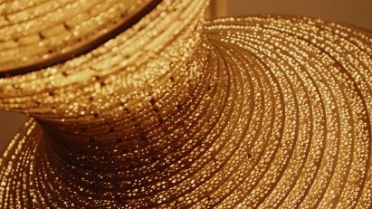 Macro detail showing glowing perforations on the light sculpture's surface