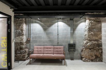 Stone walls and sofa inside youth arts hub