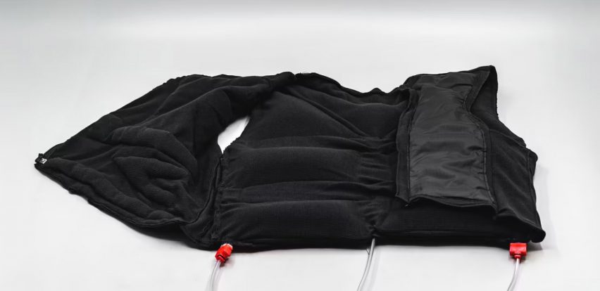 a photograph of a black vest garment laid flat