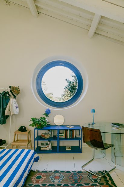 Bedroom with rose window in Pailunga converted chapel by Atelier Vago