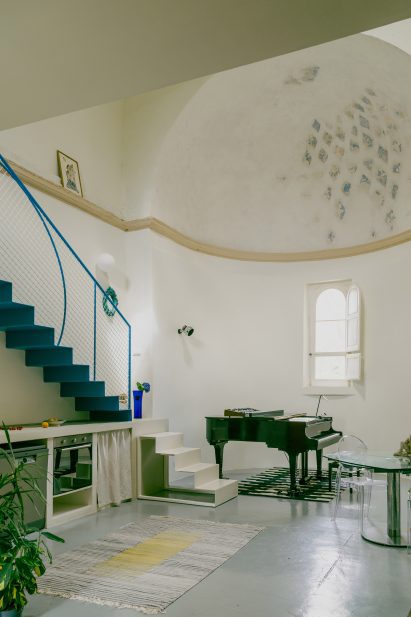 Piano, staircase and apse in Pailunga converted chapel by Atelier Vago