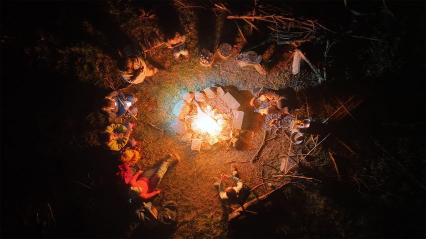 an image showing people sat round a bonfire, from above