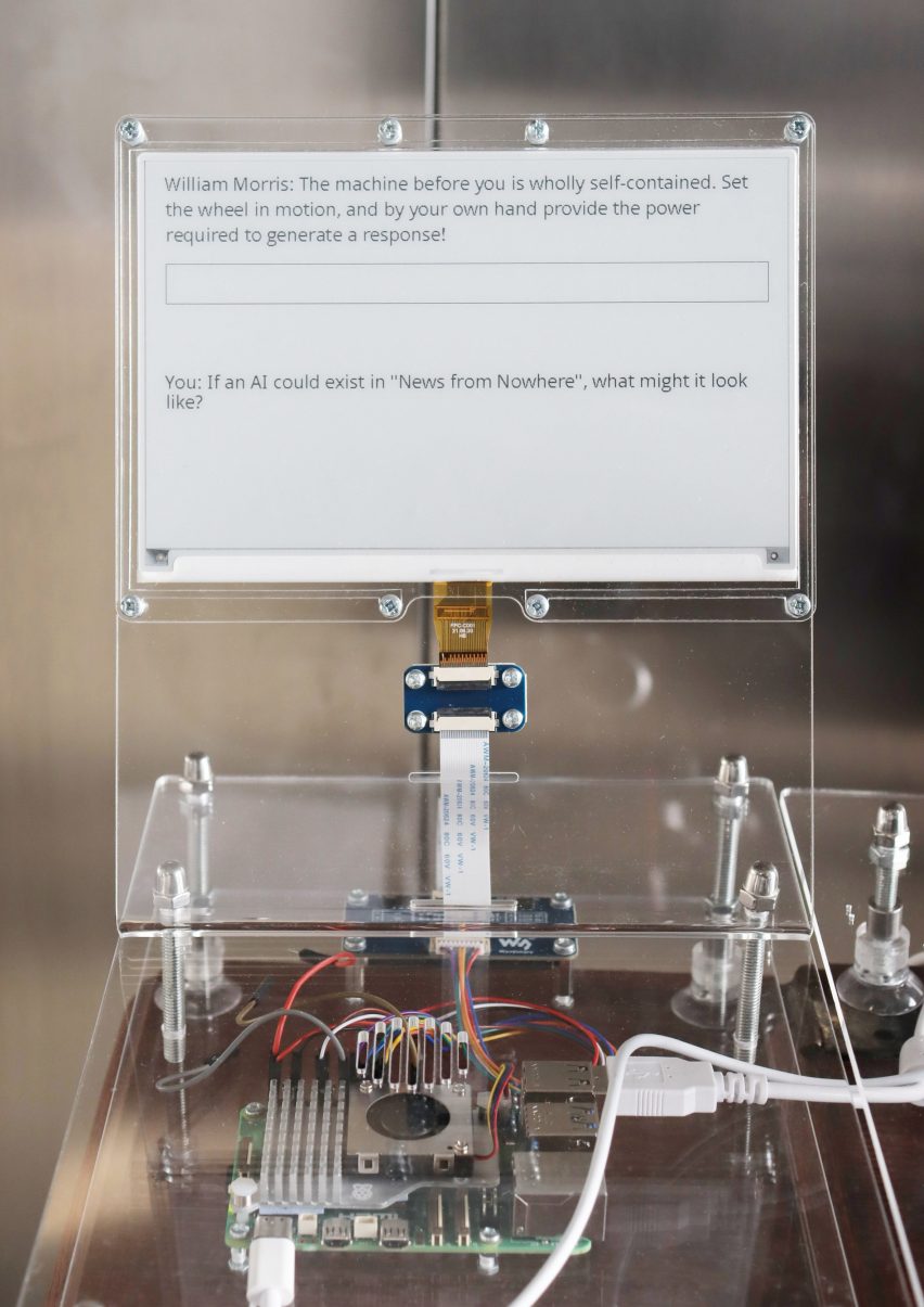 Close-up photo of an e-paper screen with writing on it above a steampunk-like hardware set-up for the Prompting Nowhere project