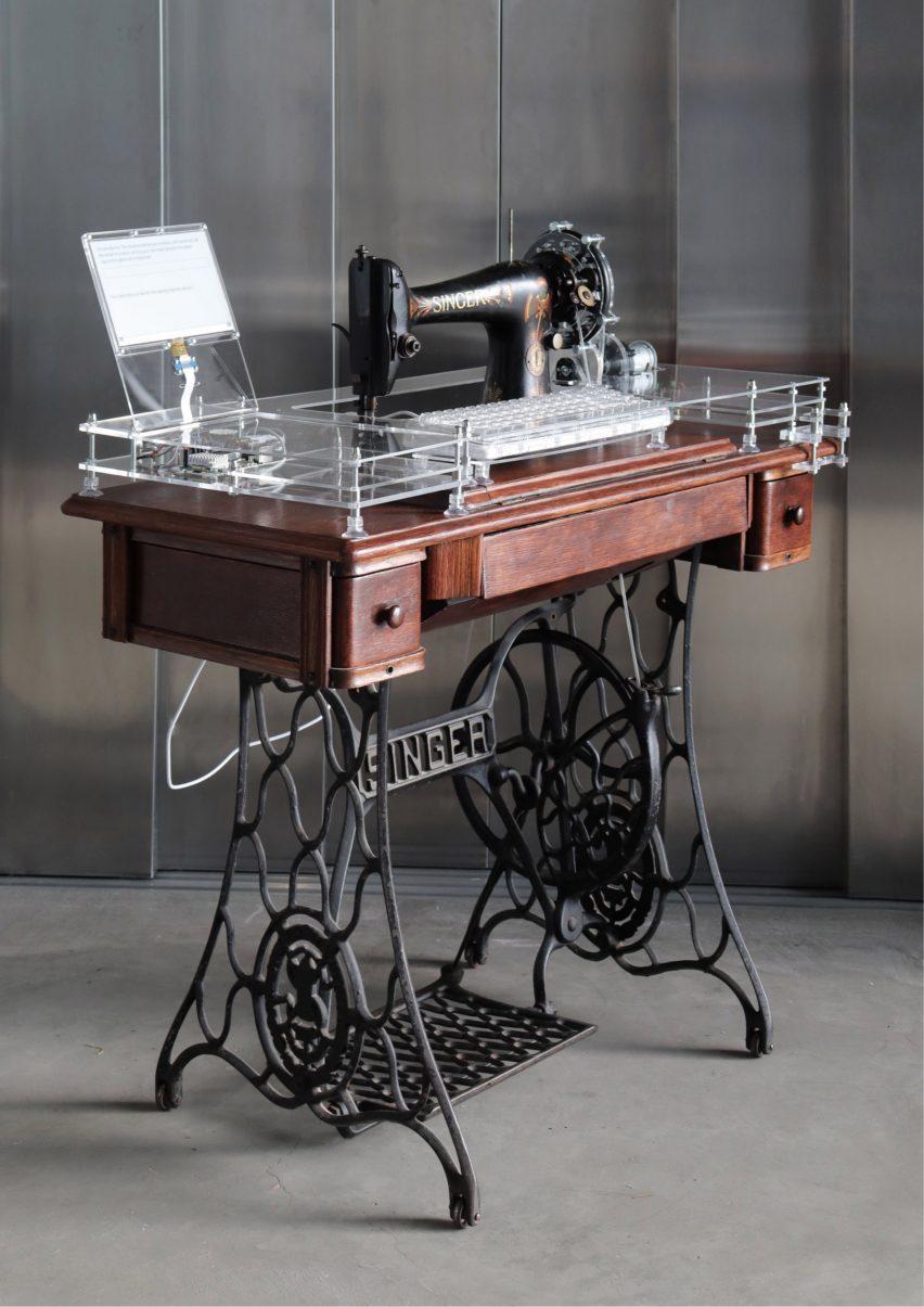 Photo of an old Singer treadle sewing machine modified to have a perspex top with computer components inside running a local AI