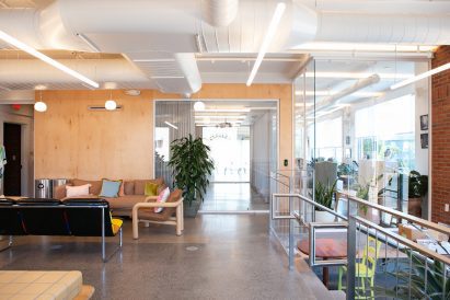 Cafe area with eclectic furniture, plywood walls and glass partitions