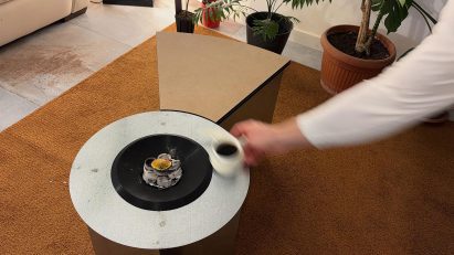 a person placing a cup on a coffee table