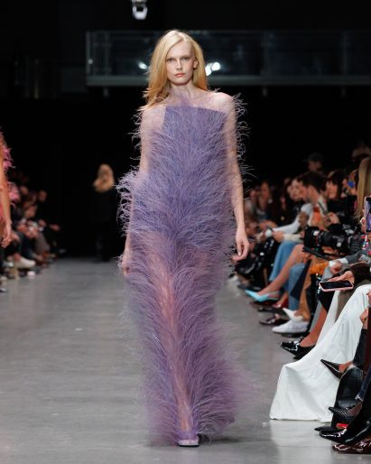 Plant-based Fevvers feathers on a long purple gown in the Stella McCartney Spring/Summer26 show at Paris Fashion Week