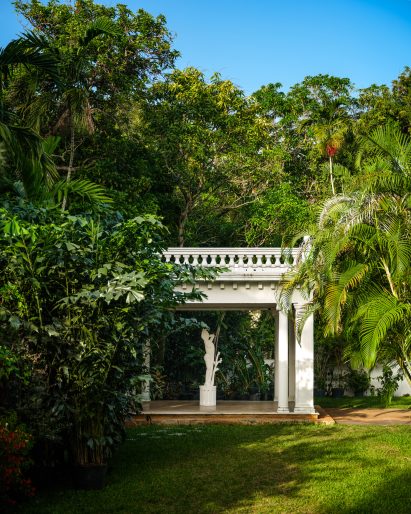 Garden with a white pavilion surrounded by tropical flora
