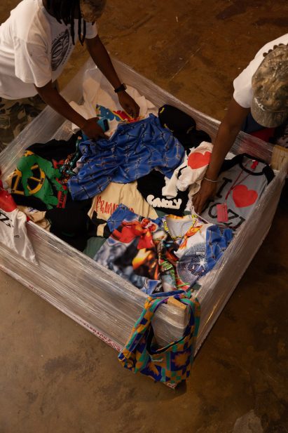 People digging through a bale of clothes