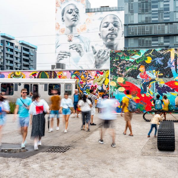 Photo of people surrounded by murals