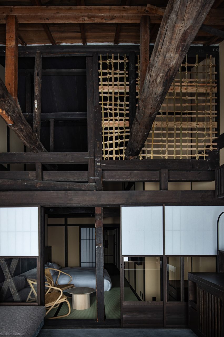 A photograph showing one of the guest bedrooms with an extensive wooden beam structure and washi-paper screens.