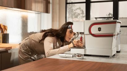 Woman using Victorinox tool to adjust espresso machine