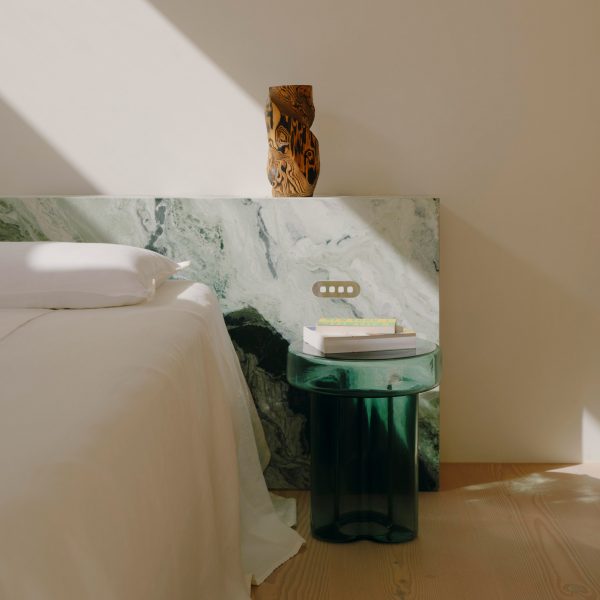 Bedside area with green glass table