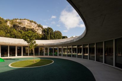 An overhanging concrete roof shelters an outdoor circulation path