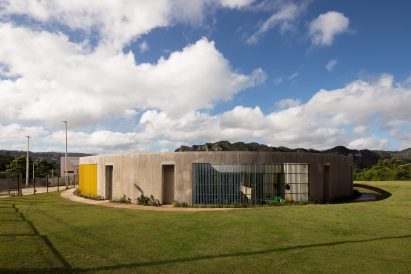 Ring-shaped concrete buildings surrounded by a grassy field