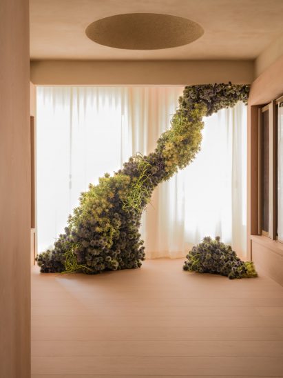 A dramatic floral sculpture sits in a window
