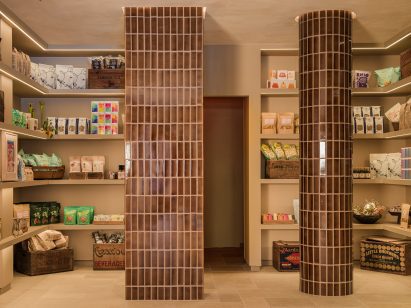 Mottled brown tiles wrap columns beside pantry goods
