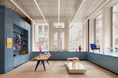 Retail space with blue display units running under windows on two sides