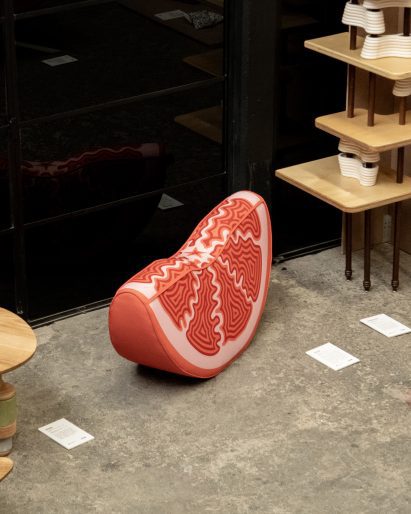 a cushion in the form of a citrus fruit segment, in tones of pink and red
