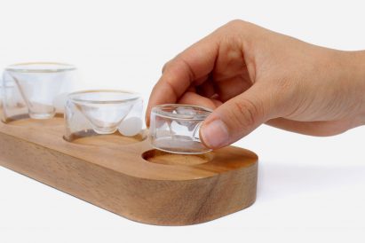 a photograph of a person's hand holding a glass vessel