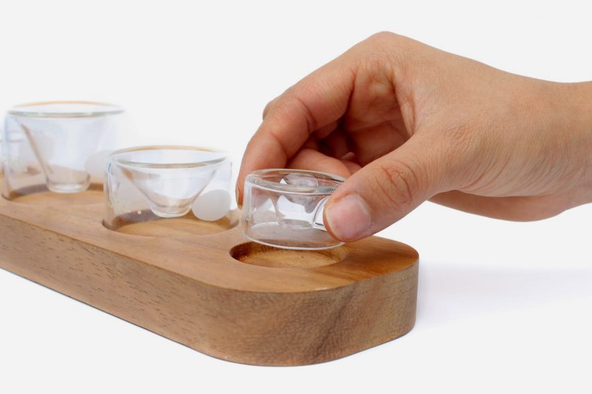 a photograph of a person's hand holding a glass vessel