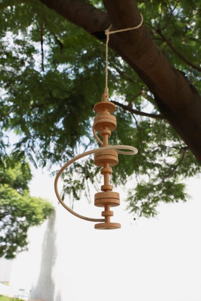 a photograph of a wooden ornament hanging from a tree