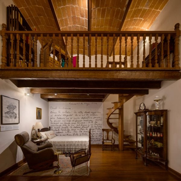 Room with a mezzanine accessed via a spiral staircase, and a vaulted tiled ceiling