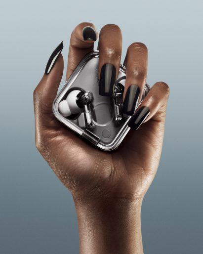 Hand holding headphone case by Nothing