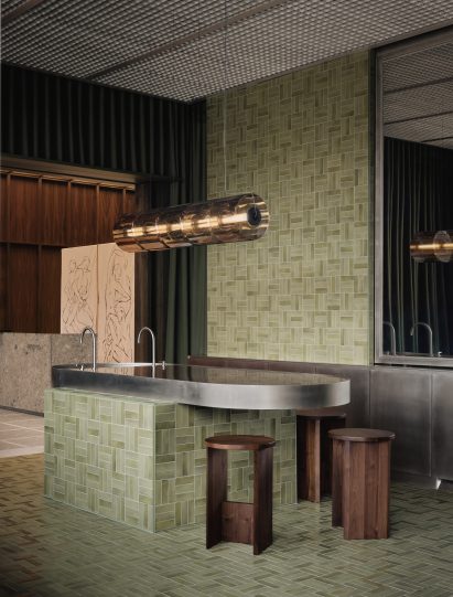 A cafe area dominated by green tiles laid in an alternating triple-stack pattern