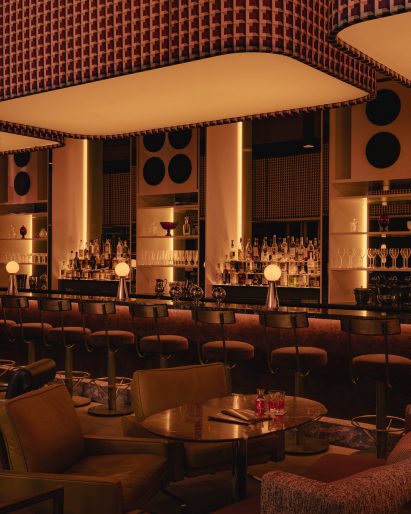 Bar and lounge illuminated with a row of light boxes wrapped in patterned fabric