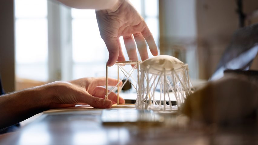 a person handling a furniture model