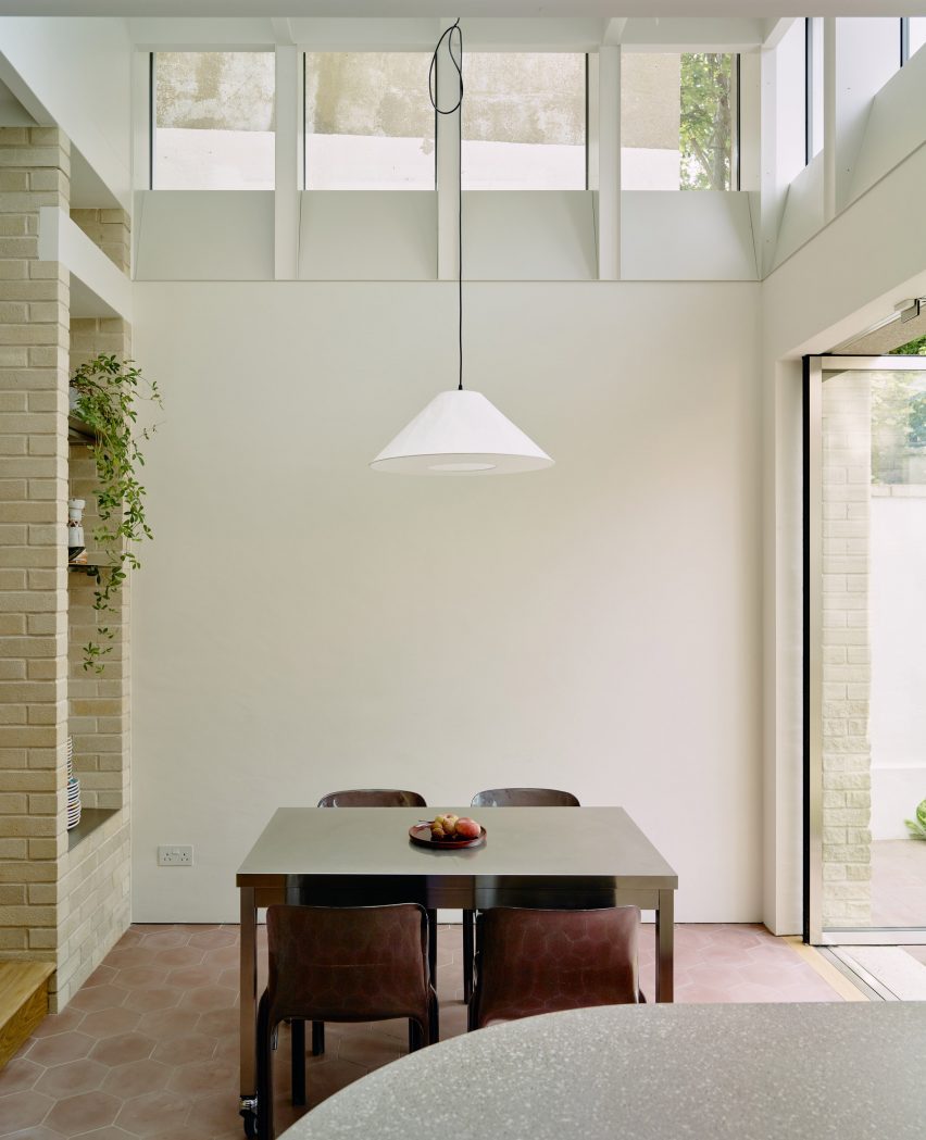 Dining table below clerestory windows in Stone and Steel House extension by DGN Studio and Sarah Izod